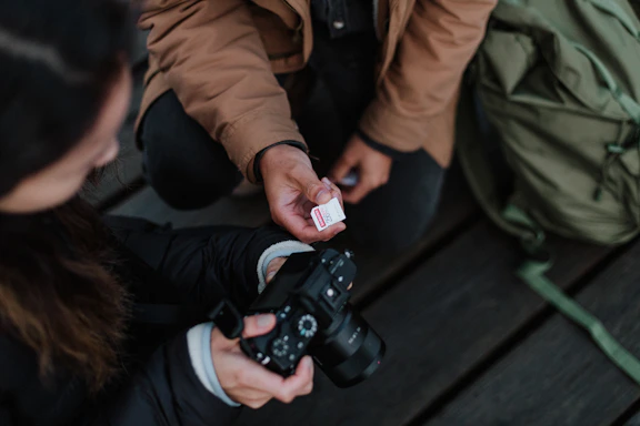 A friendly photographer talking to a client while reviewing photos on a camera.
