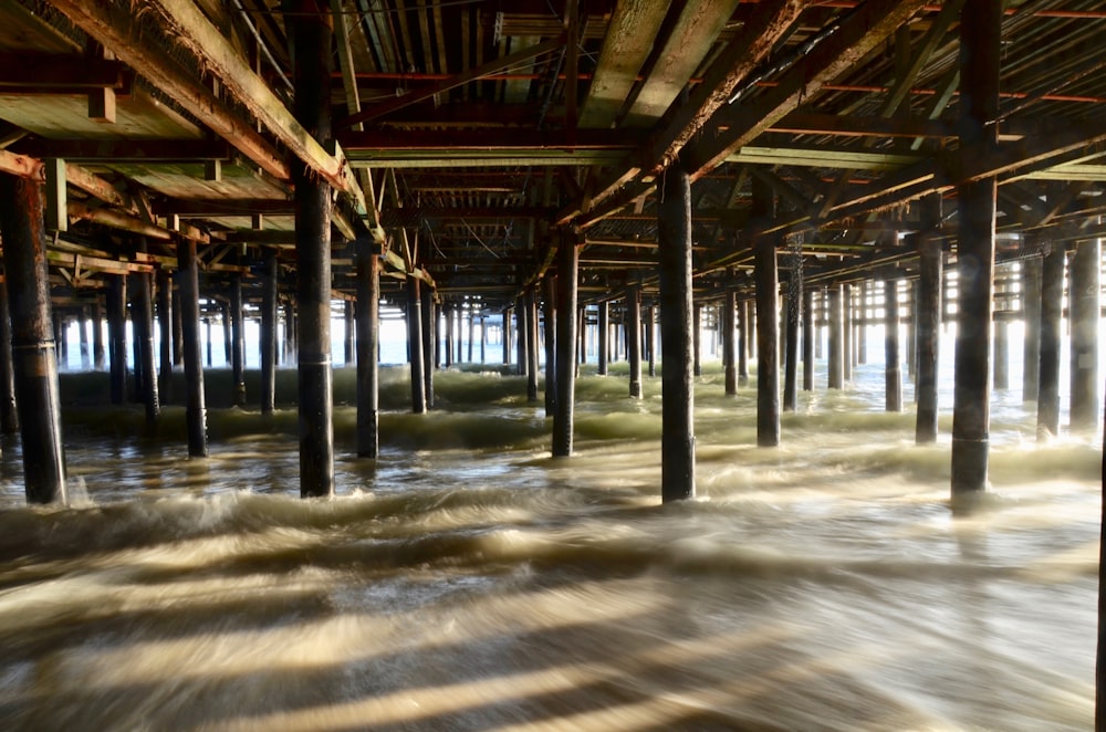 brown wooden dock under white clouds during daytime