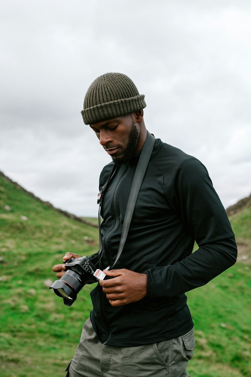 man in black jacket holding black dslr camera