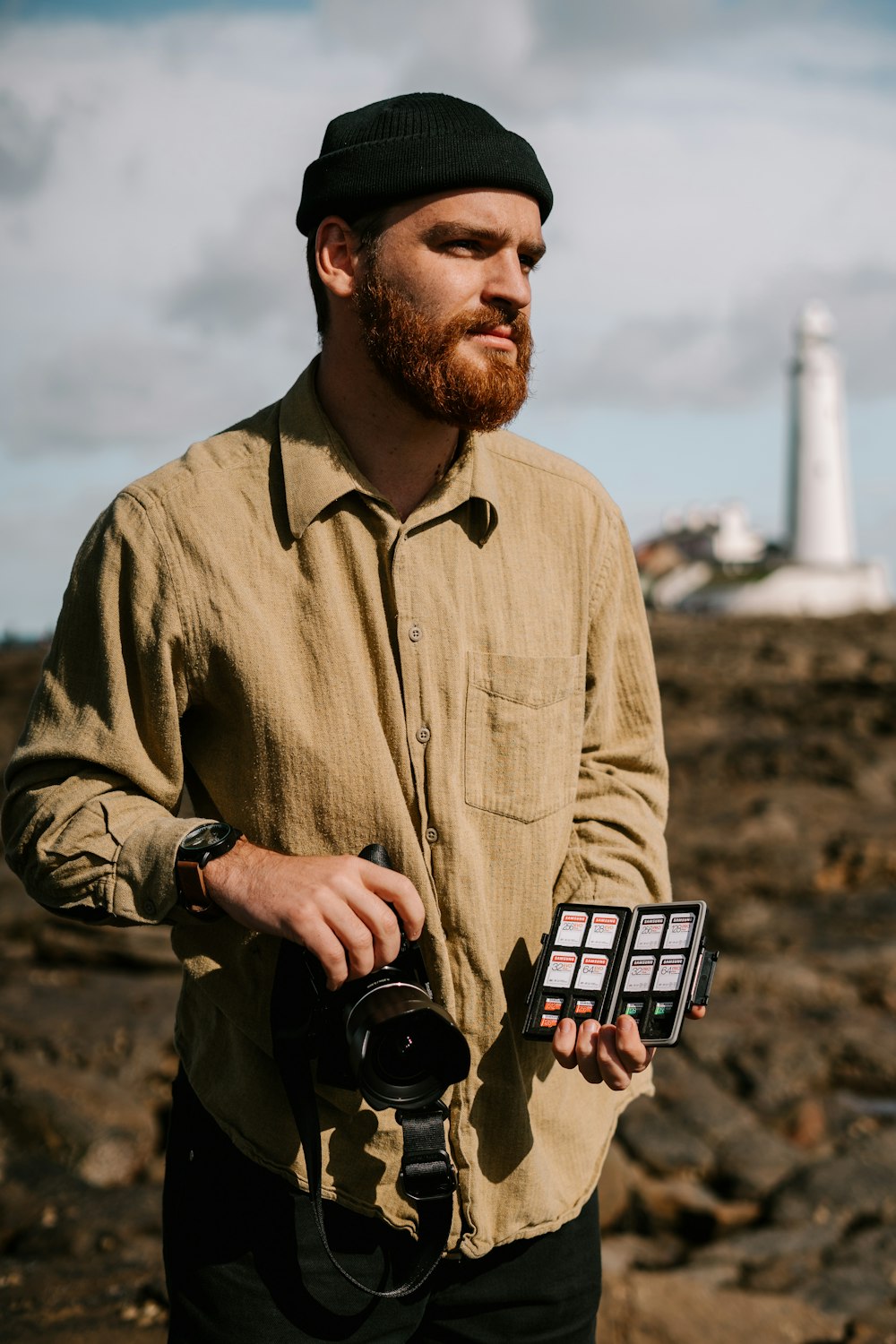 Mann in braunem Button-Up-Langarmhemd mit schwarzer DSLR-Kamera