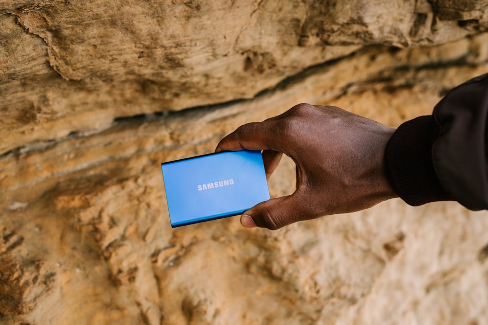 person holding blue and white box