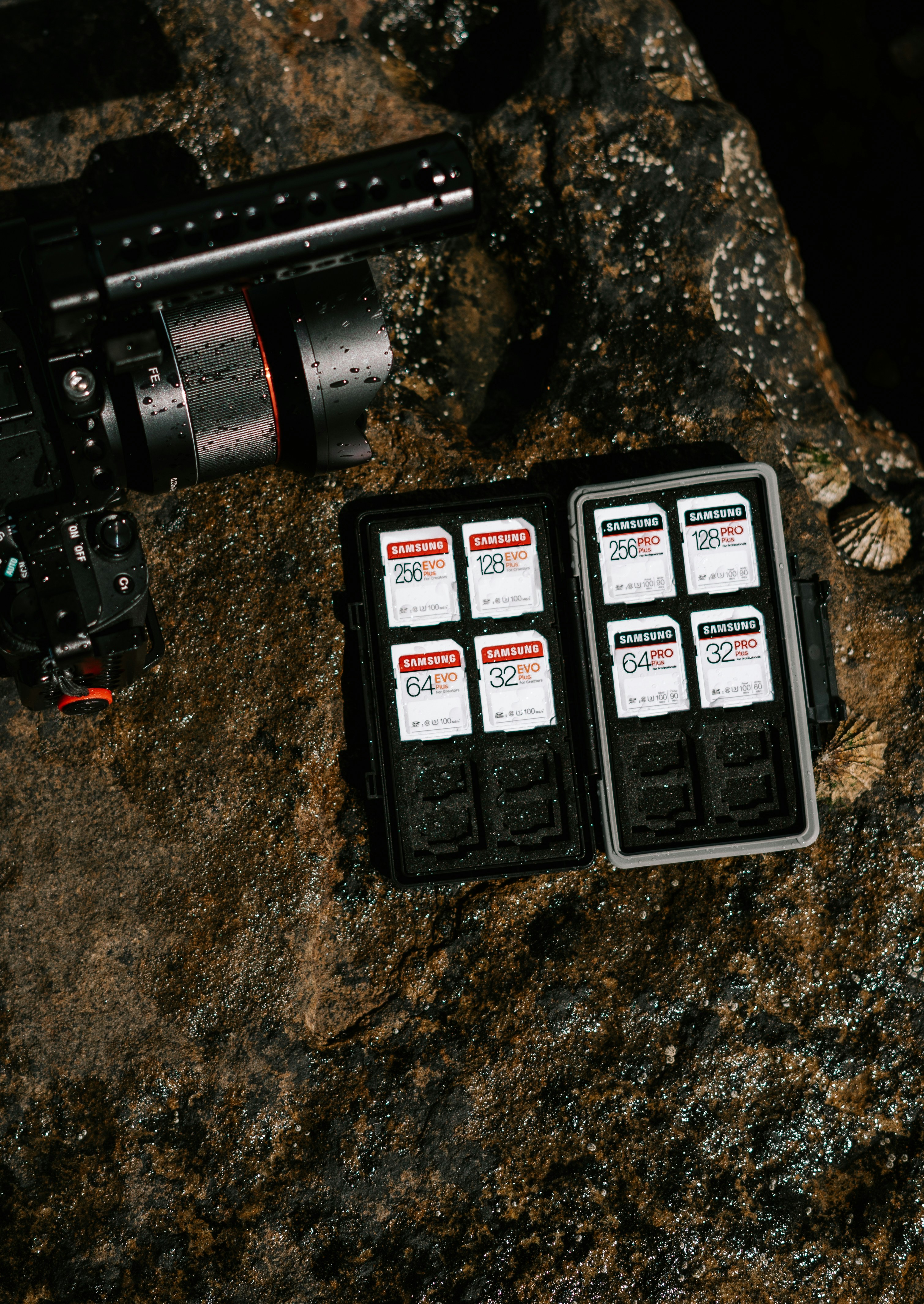 schwarz-graues Kameraobjektiv auf braunem und schwarzem Stein