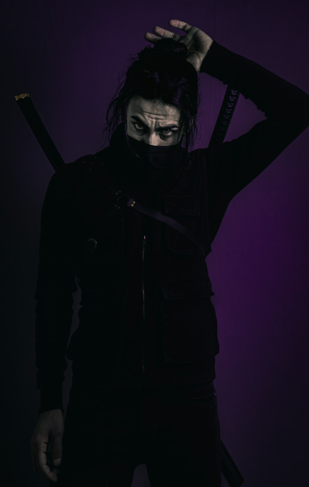 man in black jacket holding black stick