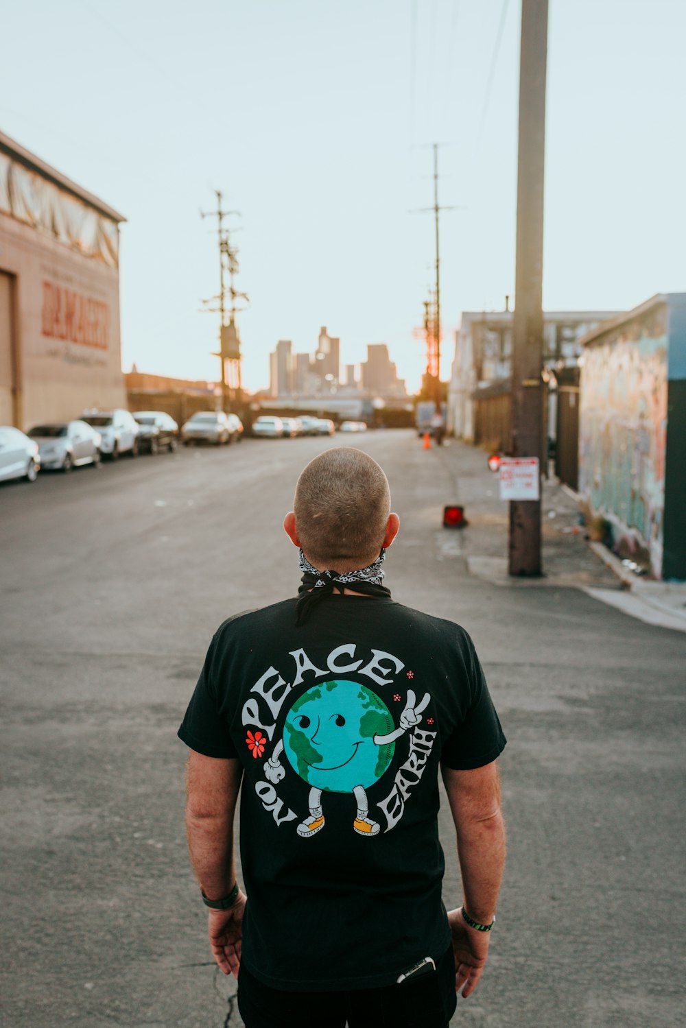 man in black crew neck t-shirt standing on sidewalk during daytime