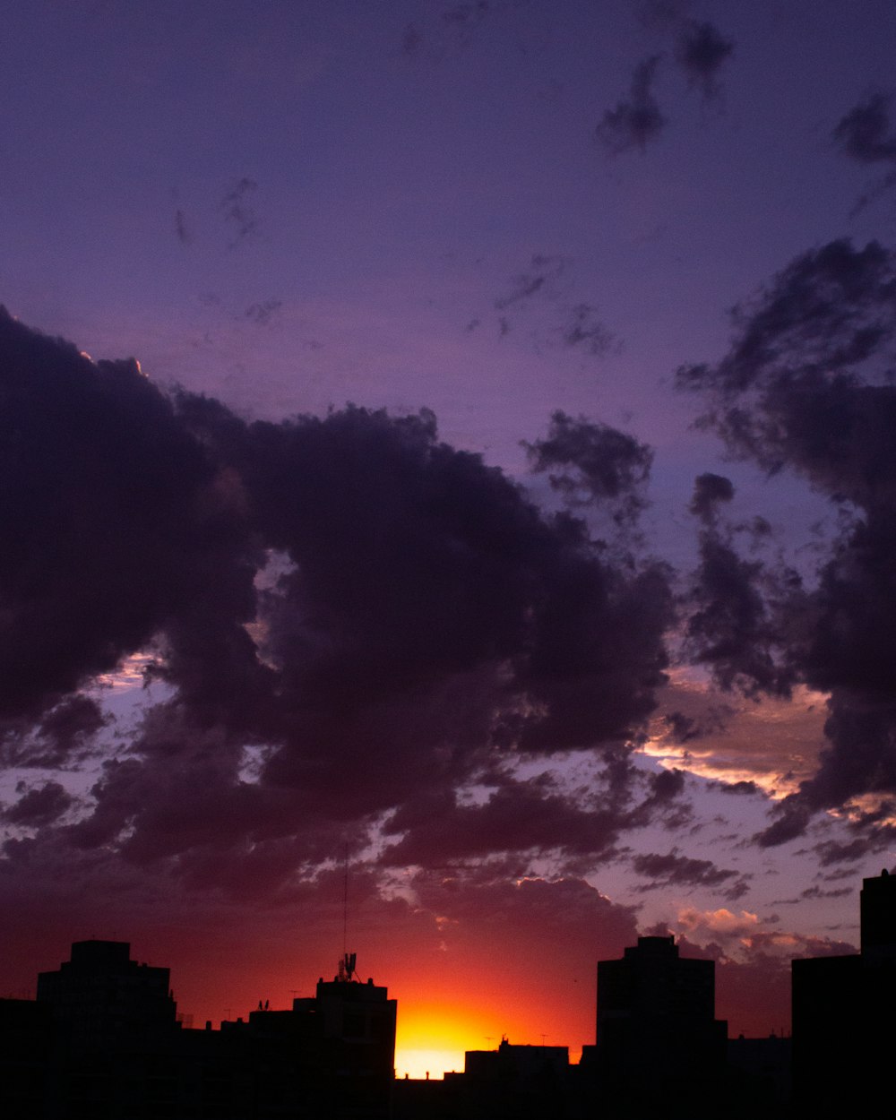 silhouette of mountain under cloudy sky during sunset