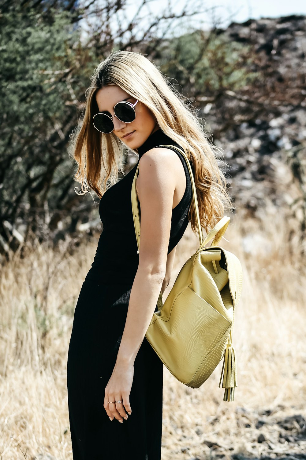 a woman in a black dress carrying a yellow purse