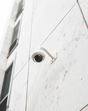 Close-up of a sleek security camera mounted on a commercial building exterior