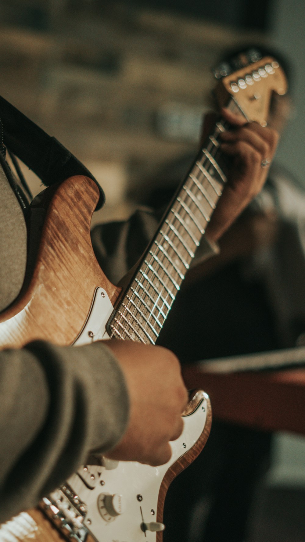 person playing brown and white electric guitar