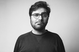 man in black crew neck shirt wearing black framed eyeglasses