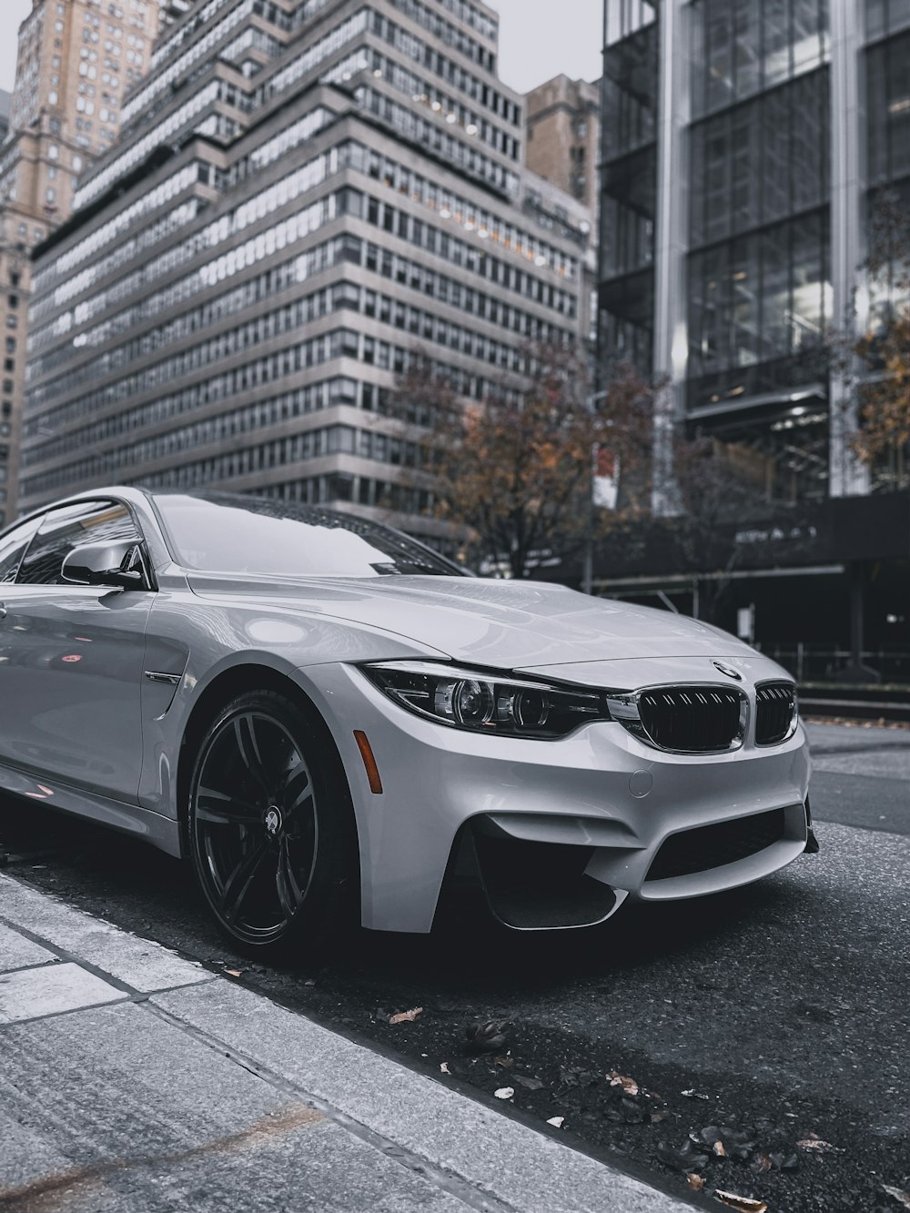 BMW M 3 Coupé blanco estacionado en la acera durante el día