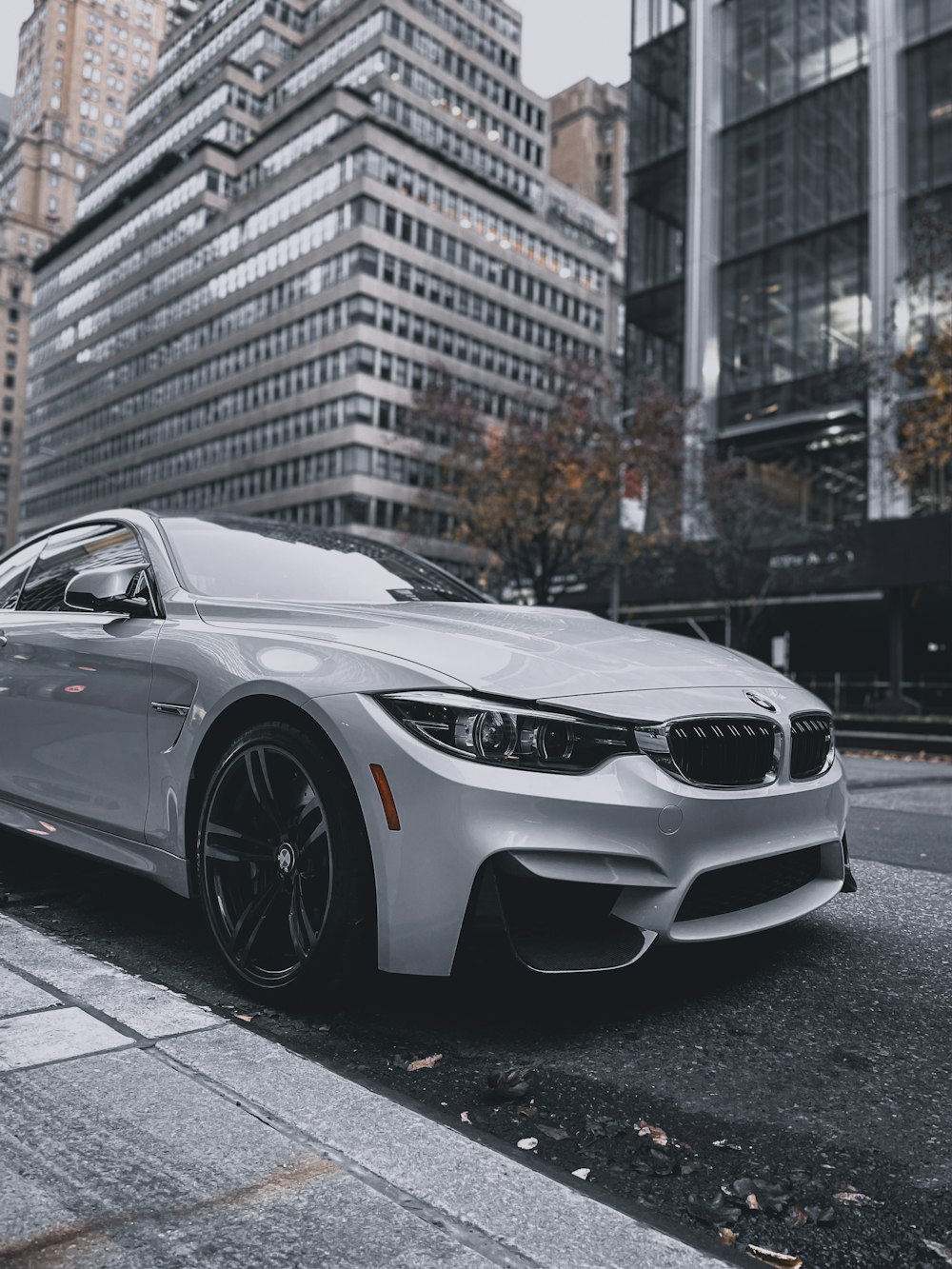 white bmw m 3 coupe parked on sidewalk during daytime