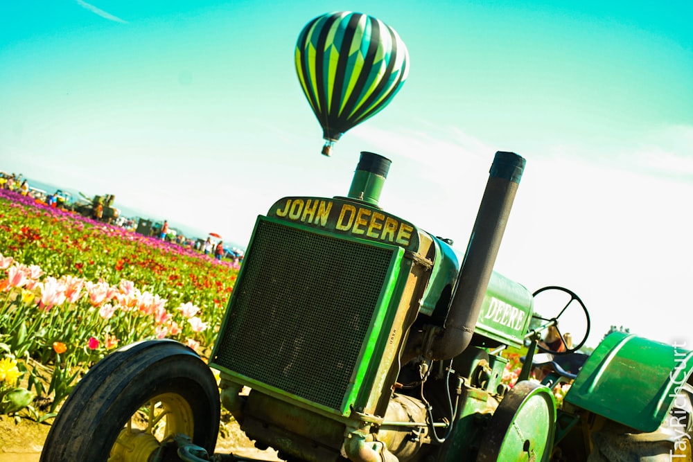 green tractor on yellow flower field during daytime