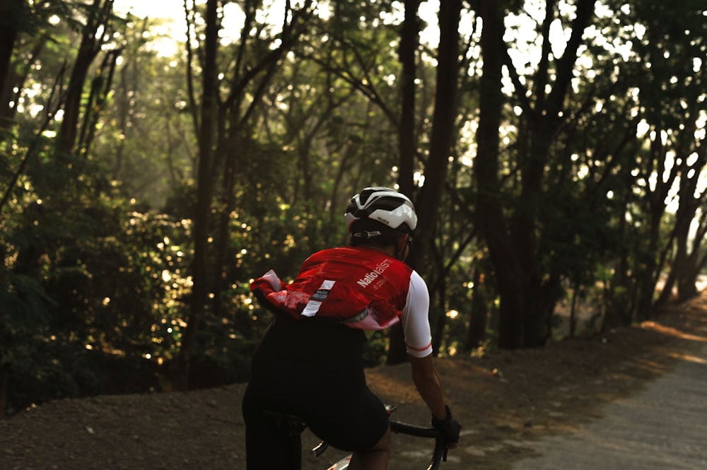 man in red shirt riding bicycle
