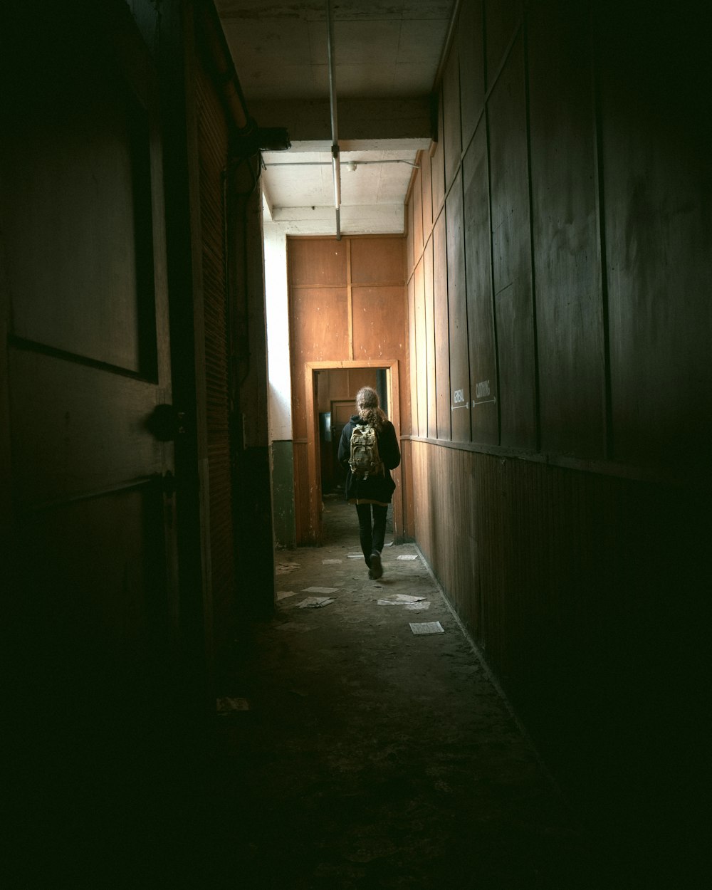 person in black jacket walking on hallway