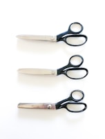 black handled scissors beside brown wooden handle knife