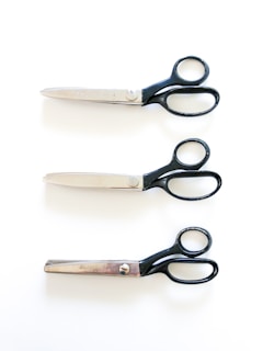 black handled scissors beside brown wooden handle knife
