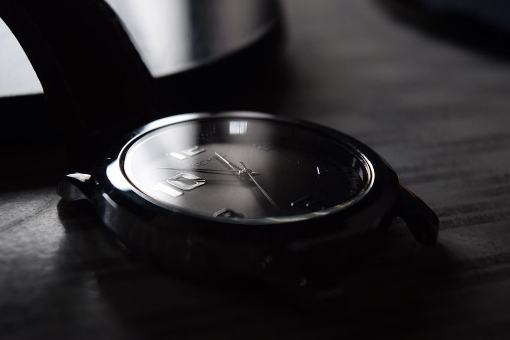 black and silver round analog watch