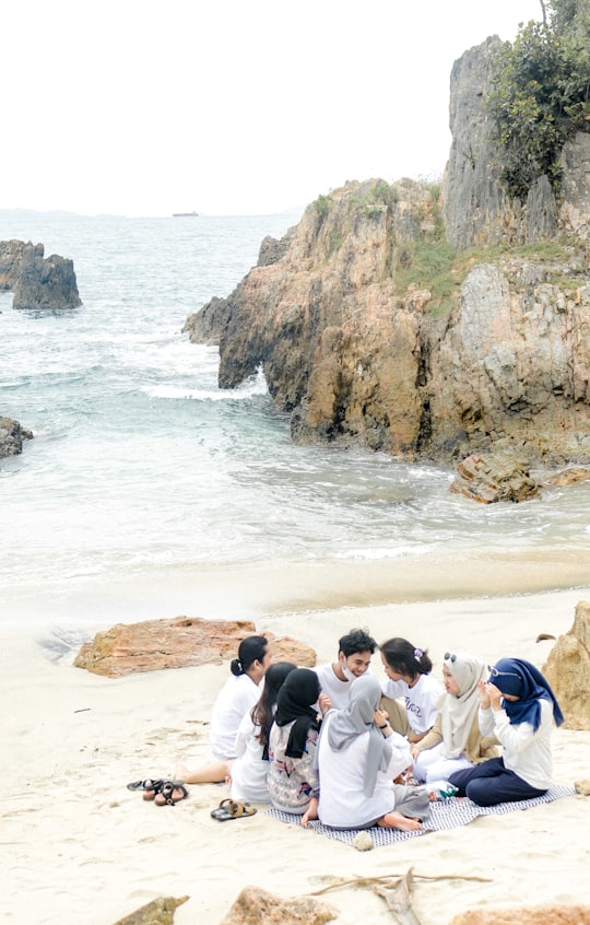 people standing on brown rocky shore during daytime in Lampung Indonesia