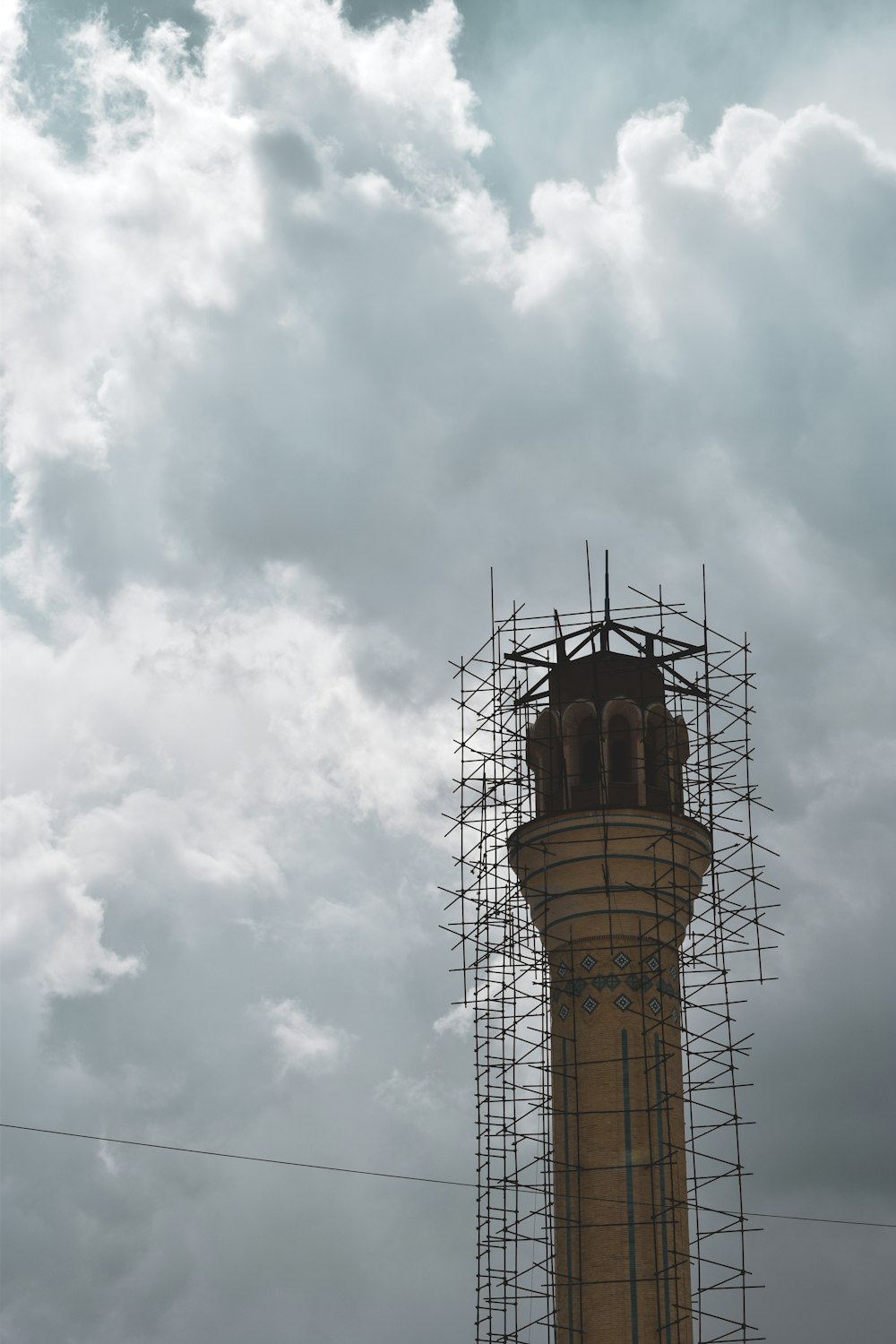 torre marrom e preta sob nuvens brancas