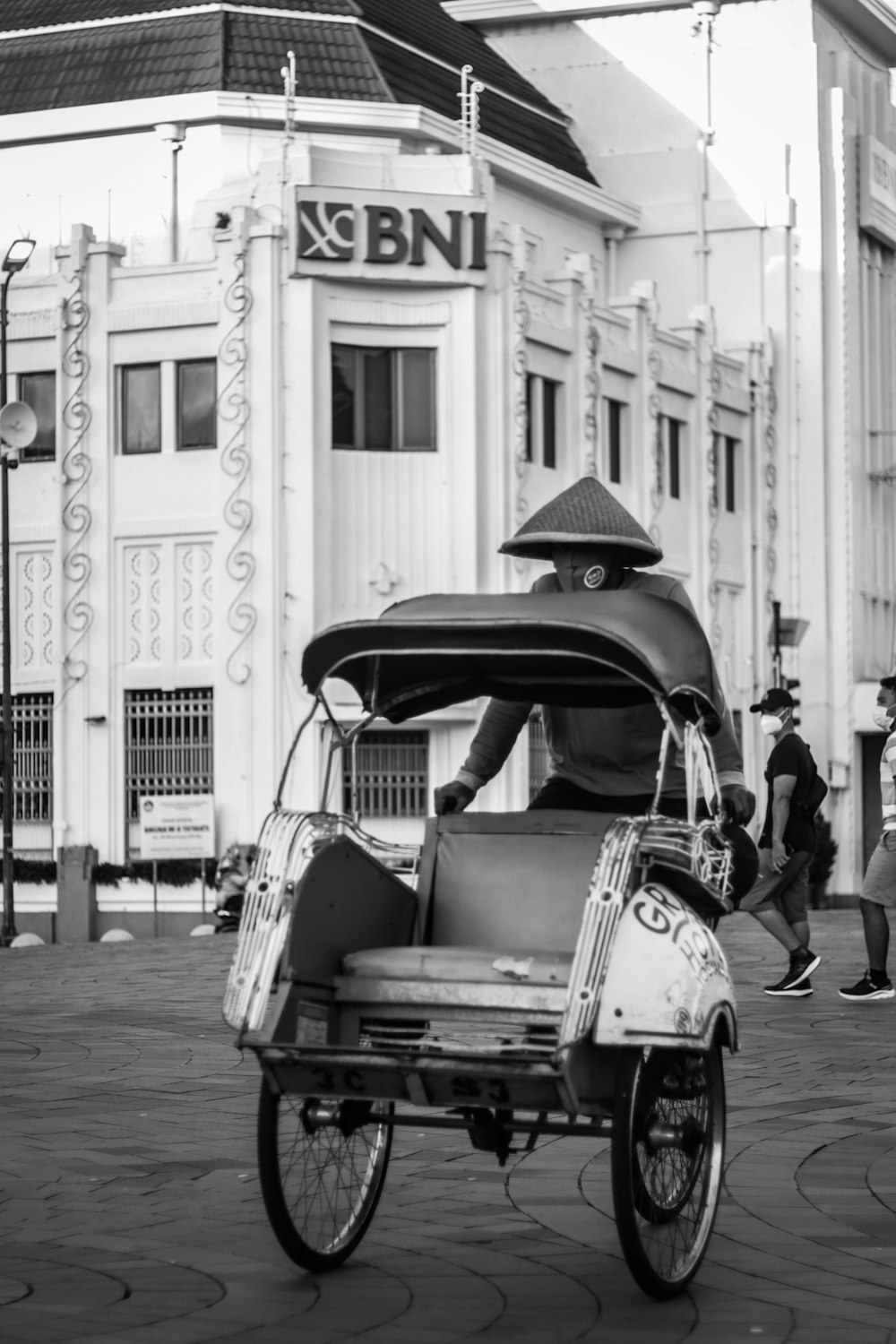 grayscale photo of 2 cars parked near building