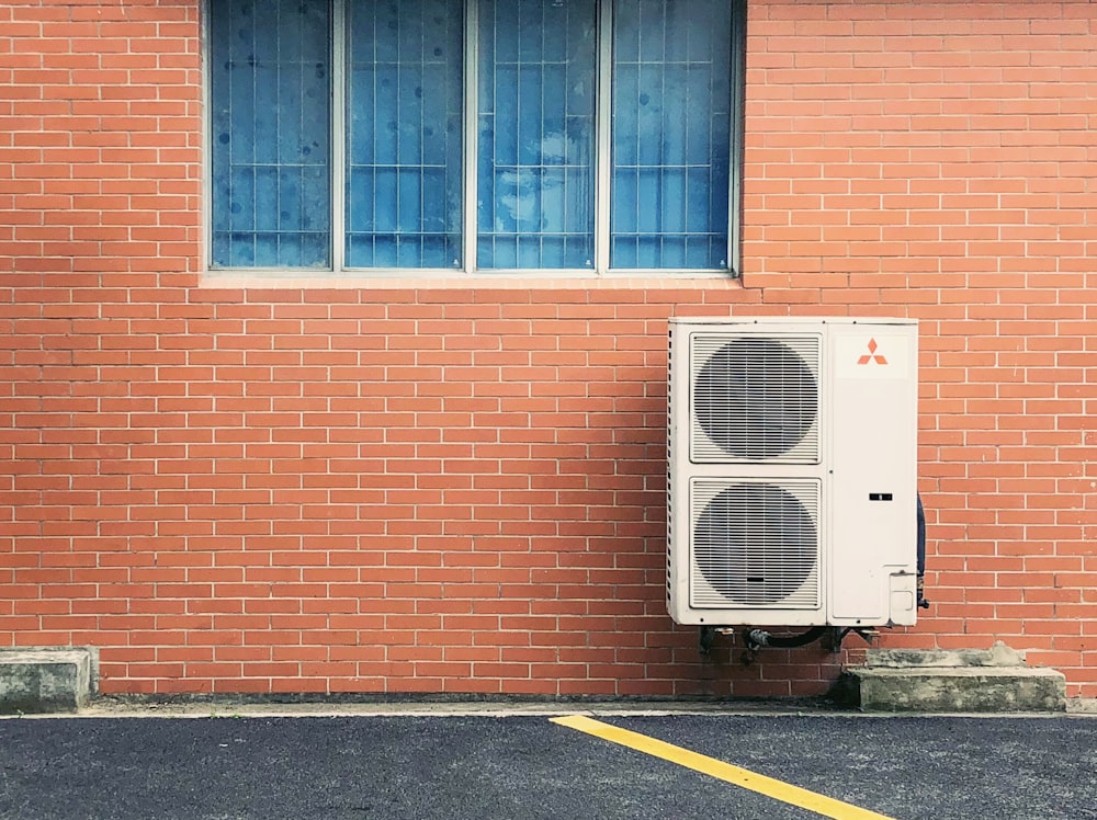 brown brick building with white window type air conditioner - common ac problems - air conditioner repair in denver co