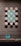 A display of intricately designed tiles with geometric and floral patterns. The tiles are arranged in a symmetrical pattern on a wall, featuring a blend of turquoise and earthy tones. A leaf-shaped ceramic ornament sits on a stand below, matching the tiles' color scheme.