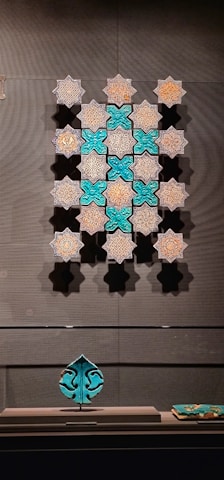 Artisan hands arranging colorful zellige tiles in a geometric pattern.