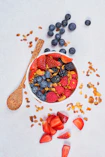 red strawberries and blue berries on white ceramic bowl