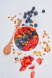 A bowl filled with mixed berries like strawberries, blueberries, and raspberries, bursting with color.