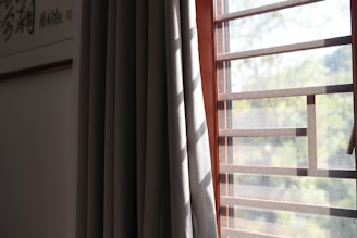 Sunlight filtering through elegant blinds and curtains in a bright room.