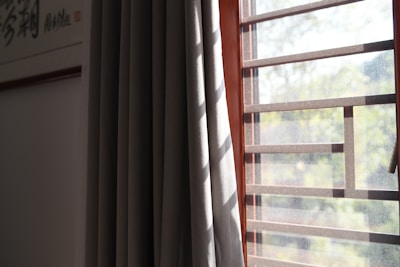 Sunlight filtering through elegant blinds and curtains in a bright room.