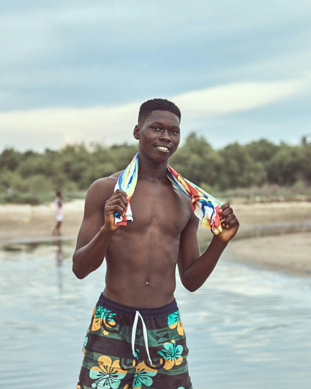 man in green and blue shorts holding blue and orange scarf