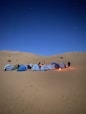 people sitting on white and red tent on brown sand during daytime