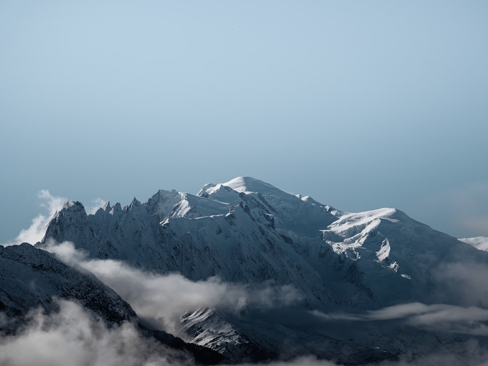 montagna coperta di neve sotto il cielo bianco durante il giorno