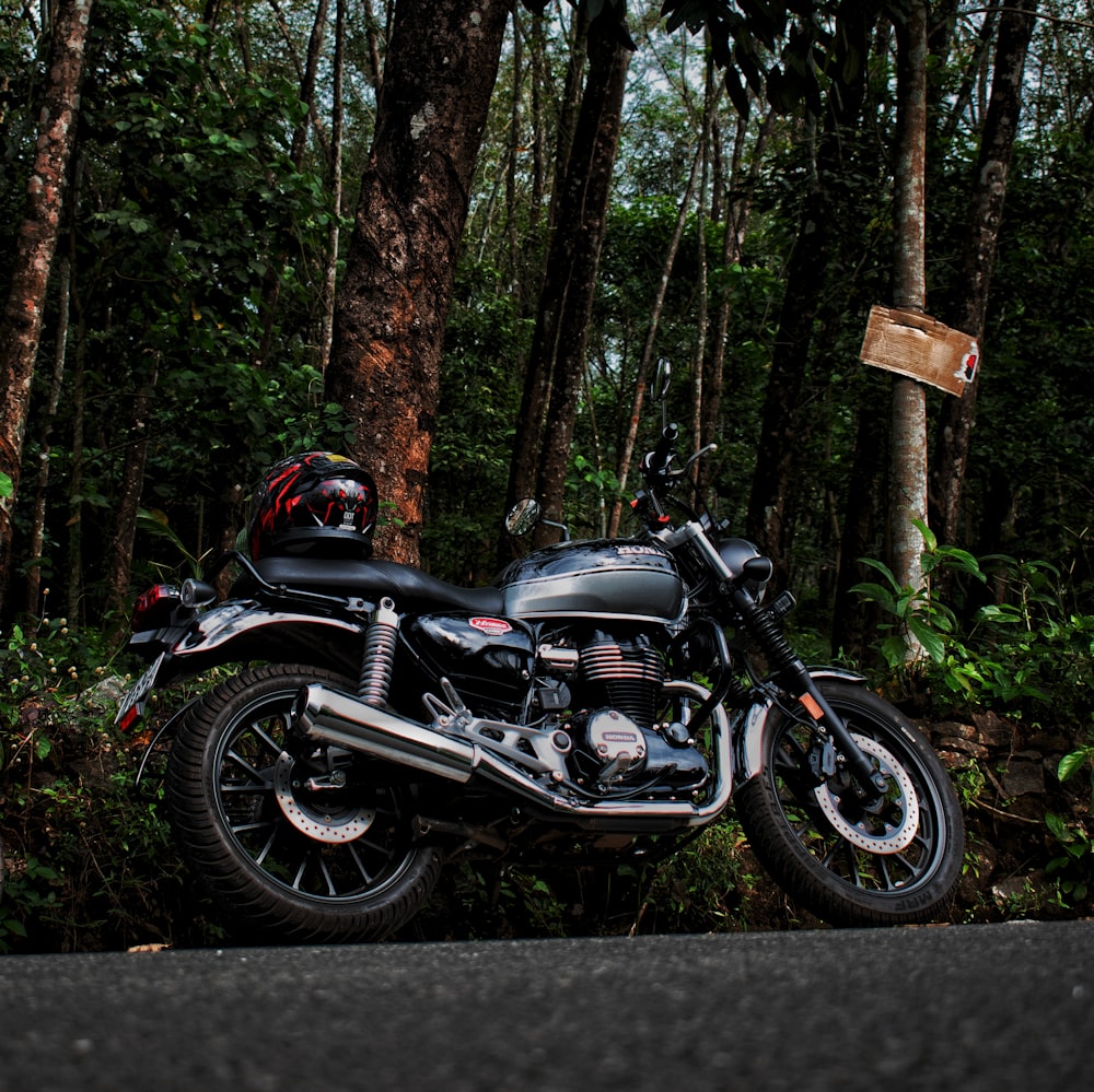 moto noire et argentée dans la forêt