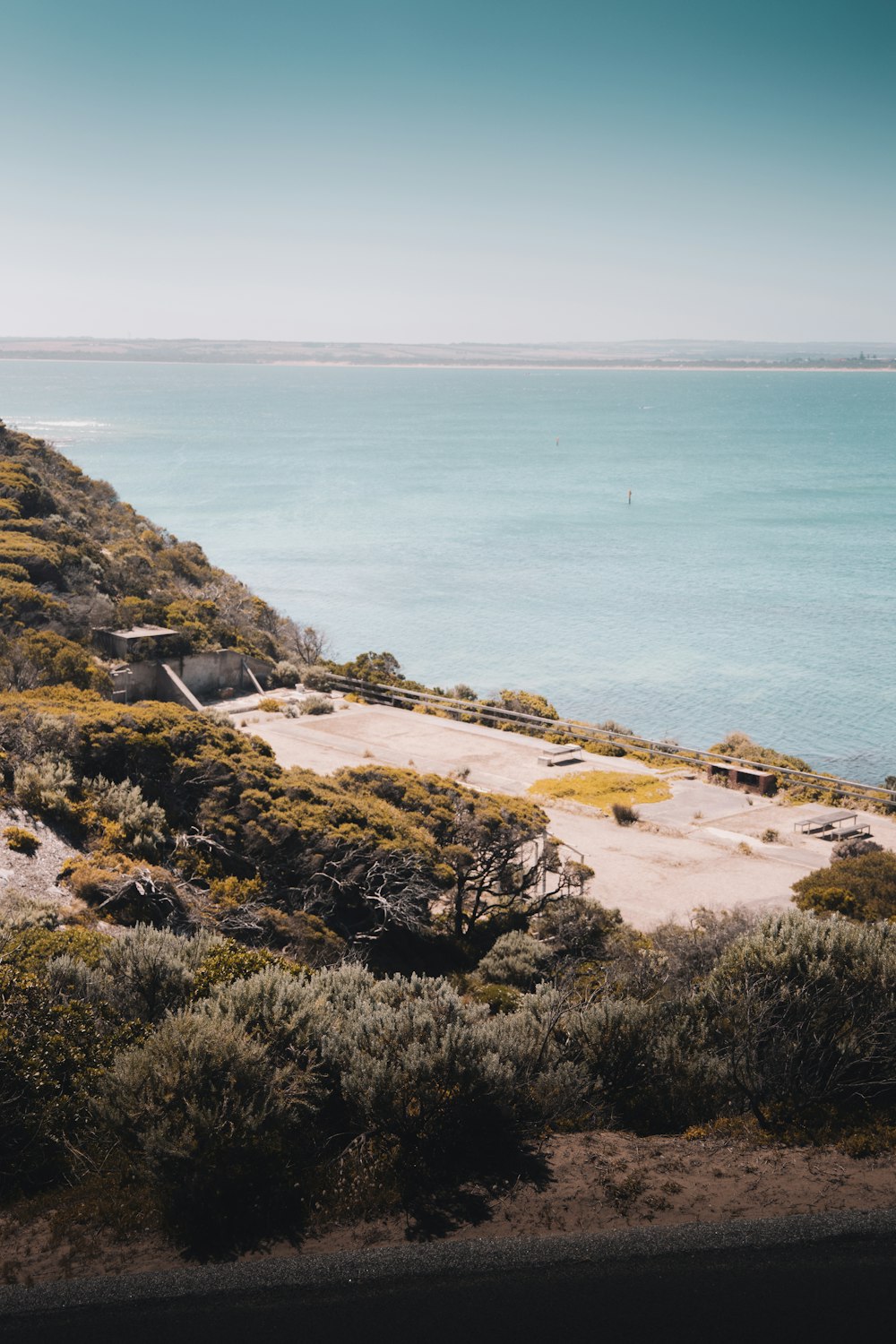 brown and green rock formation near body of water during daytime