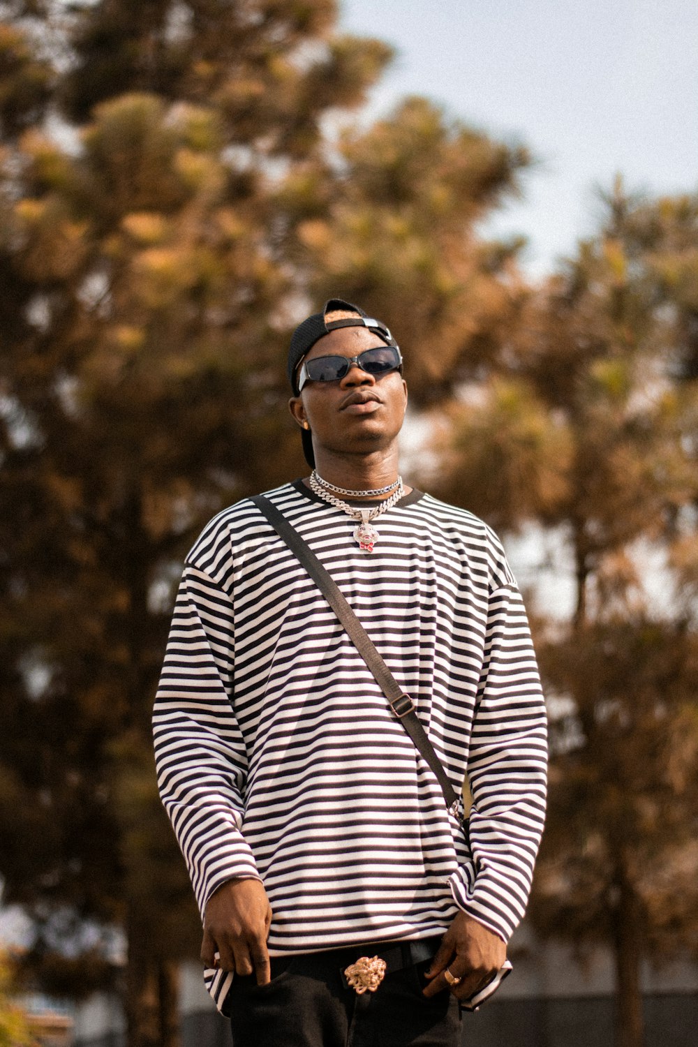 man in black and white striped long sleeve shirt wearing black sunglasses