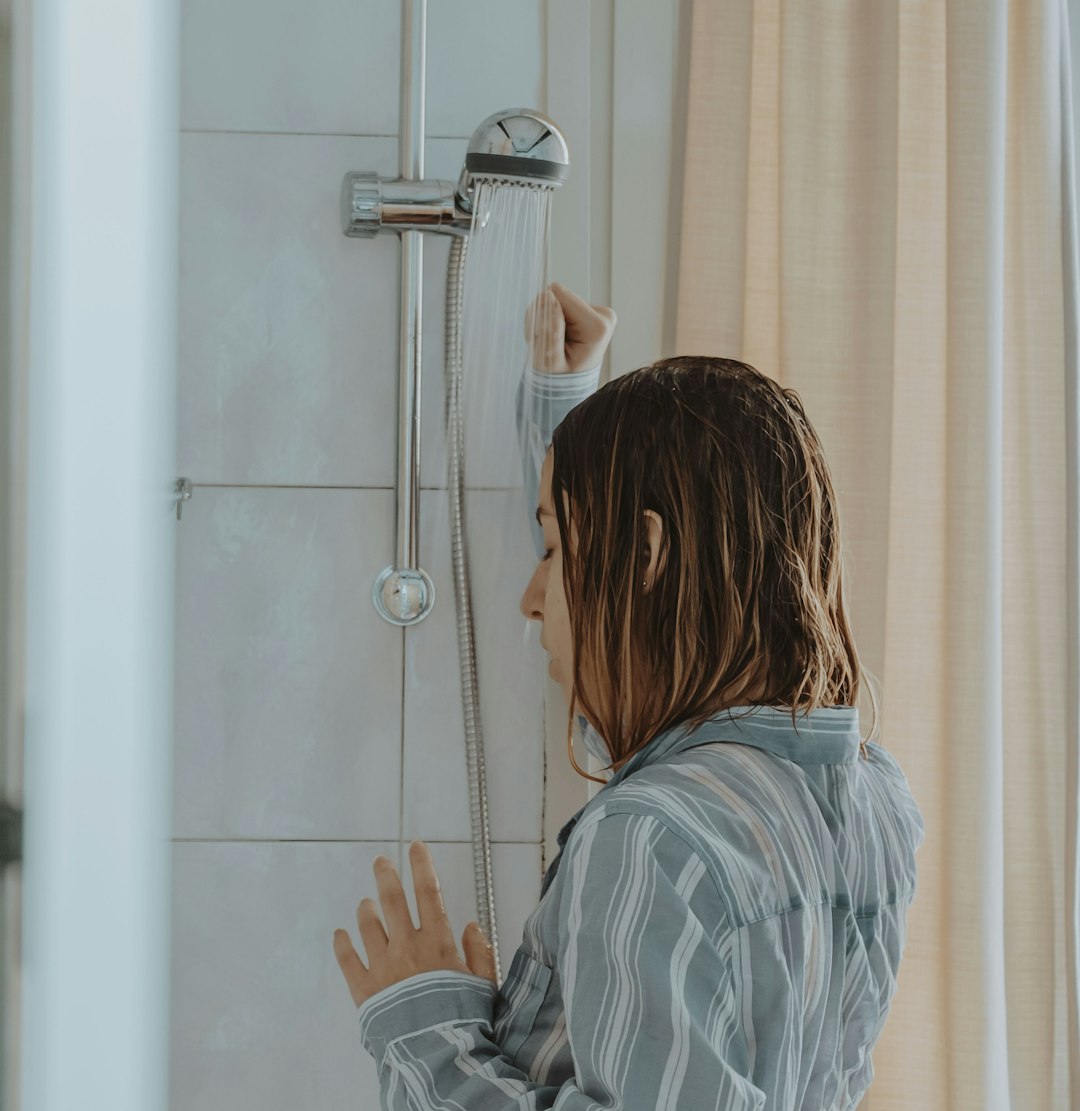 woman in blue and white stripe long sleeve shirt standing in front of white wooden door