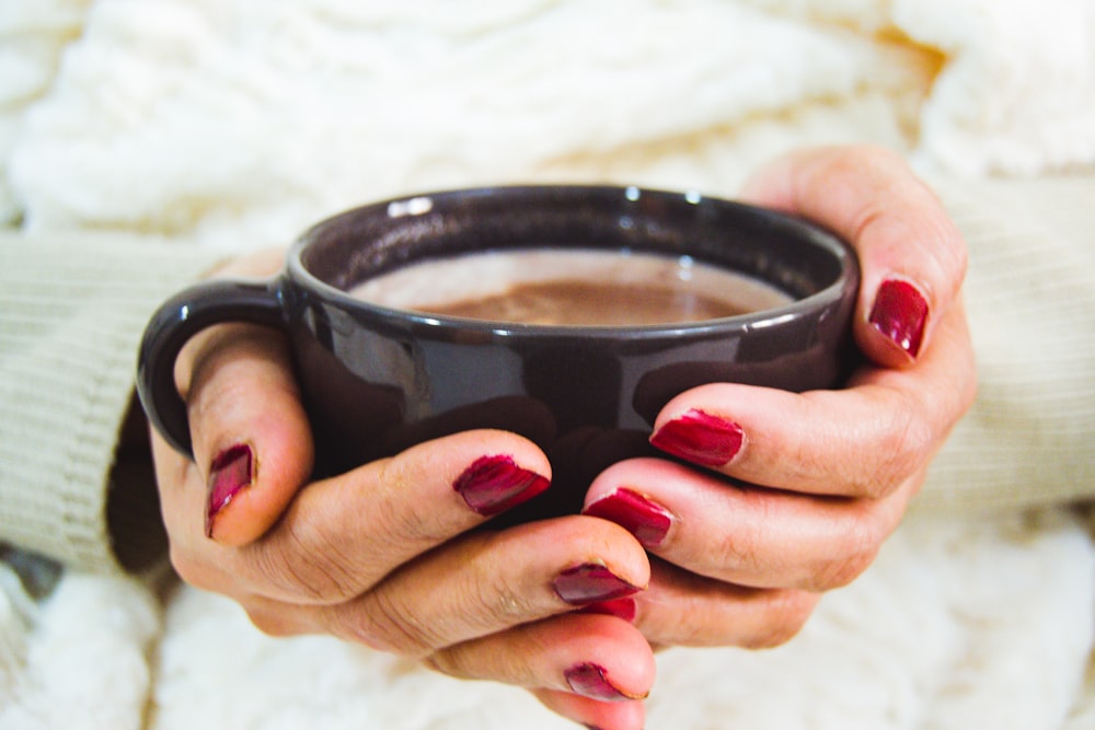 person holding black ceramic mug