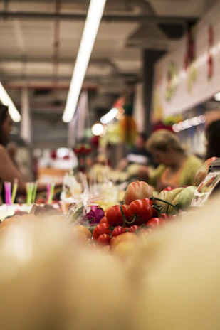 Photographer capturing detailed shots of colorful, fresh market produce in natural light.