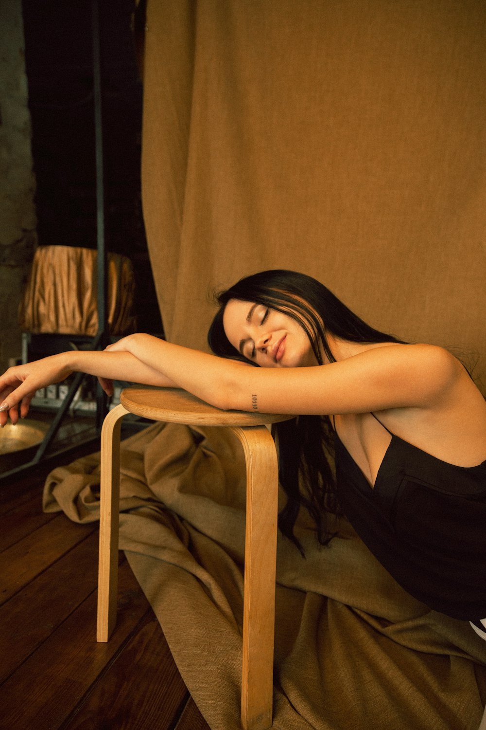 woman in black dress sitting on brown wooden chair