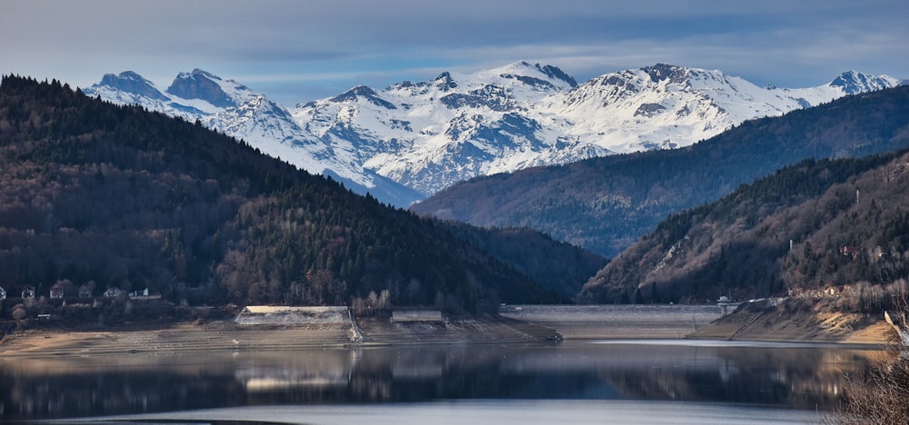 snow covered mountain near lake during daytime