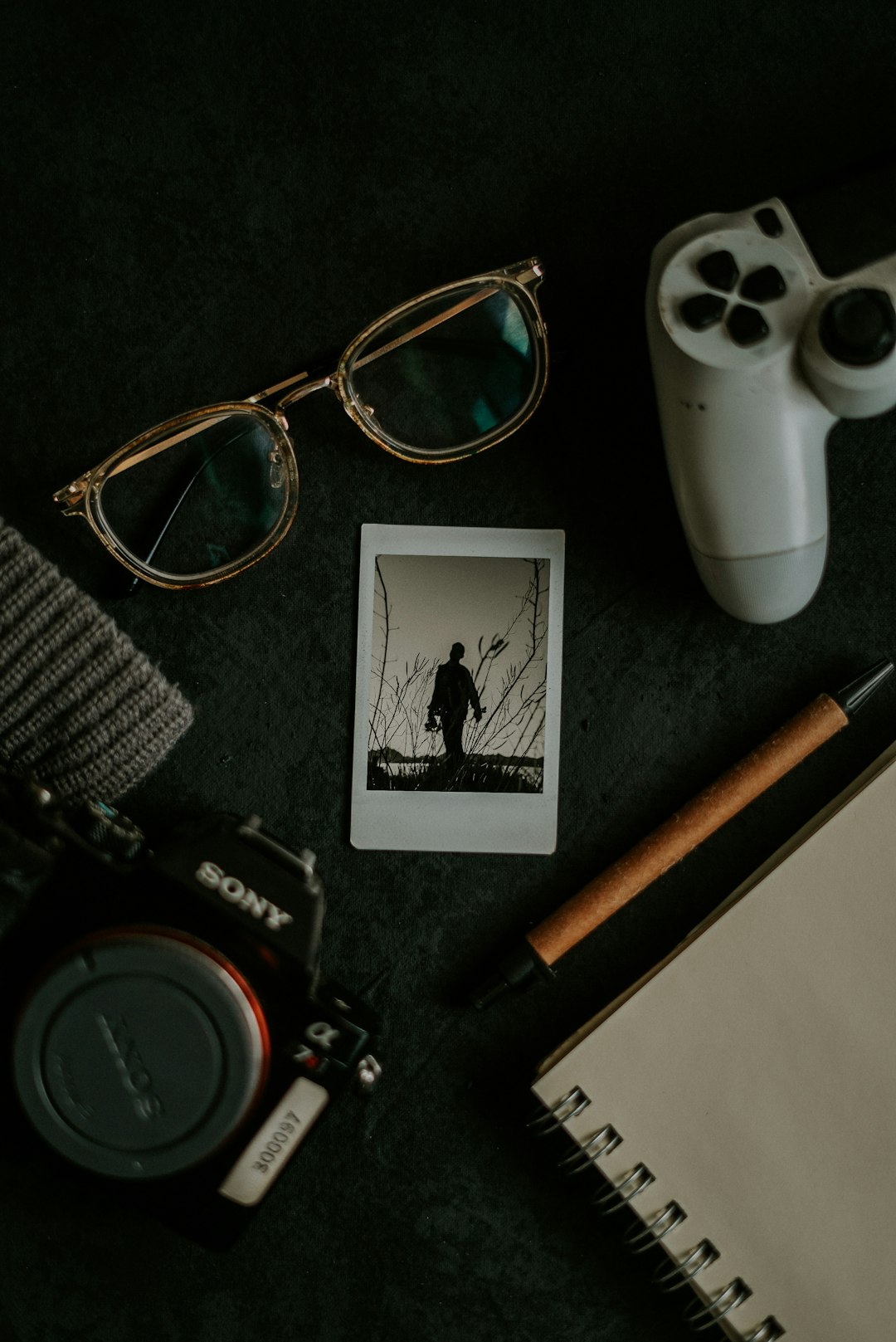 black and white sony dslr camera beside brown and black framed eyeglasses