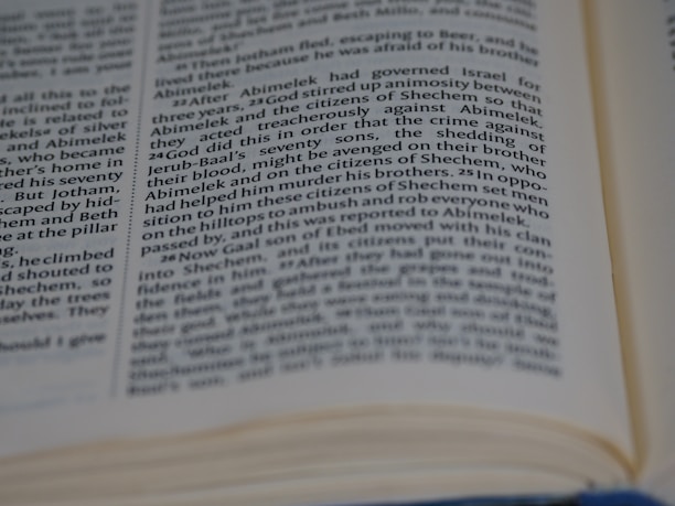 A close-up view of an open book depicting printed text. The text is focused and provides detailed information on a page, with some words slightly blurred due to the depth of field.