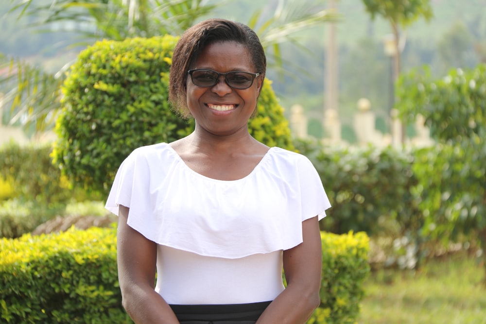 woman in white crew neck t-shirt and black skirt smiling