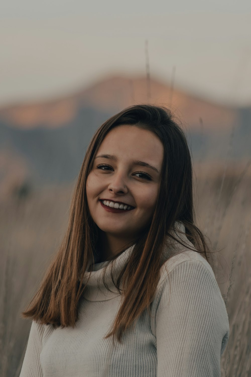 mujer sonriente en suéter blanco de cuello alto