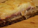 Close-up of the club house sandwich stacked high with fresh ingredients and melted cheese.