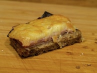 A golden ham fresh out of the oven, steam rising gently, surrounded by orange slices.