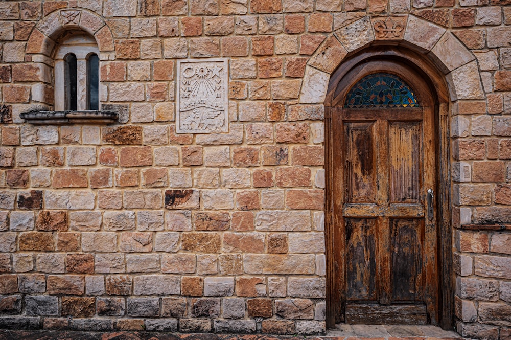 brown wooden door on brick wall