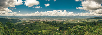 A panoramic view of a modern township with green spaces and Himalayan backdrop in Dehradun.
